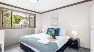a bedroom with a large bed and a window at Lionel Gem in Shoal Bay