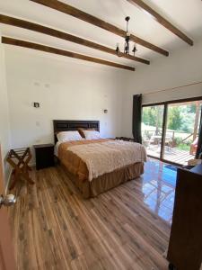 a bedroom with a bed and a large window at Hospedaje entre ríos Caipulli in Ancud