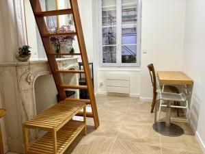a staircase in a room with a table and a chair at Chambre d'hôte Bordeaux in Bordeaux