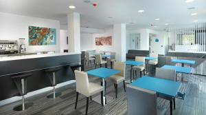 un restaurante con mesas y sillas azules y una barra en Blu9 Hotel, en Novedrate
