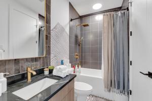 a bathroom with a sink and a toilet and a shower at Elegant Downtown Condo with Balcony & Parking in Calgary +17 photos