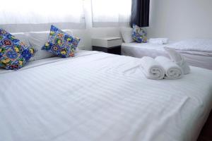 - une chambre avec 2 serviettes sur un lit blanc dans l'établissement Oskar's House, à Bangkok