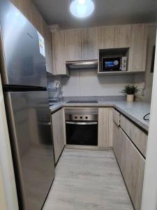 a kitchen with wooden cabinets and a stainless steel refrigerator at Terrazas del sol IV in La Serena