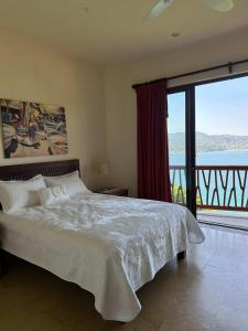 a bedroom with a bed with a view of the ocean at Luxury Residence at Vista Bay 103 in Zihuatanejo