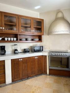 a kitchen with wooden cabinets and a stove at Luxury Residence at Vista Bay 103 in Zihuatanejo