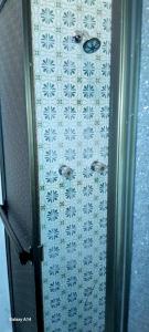 a shower door with a bunch of white tiles at Habitación 4 en Casa Retro in Medellín