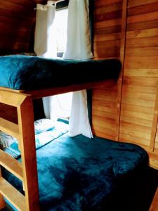 two bunk beds in a room with a window at Sitio casa di vó in Rio Forcação