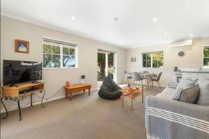 a living room with a couch and a table at Grace Cottage in Turangi
