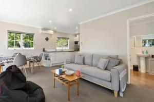 a living room with a couch and a table at Grace Cottage in Turangi