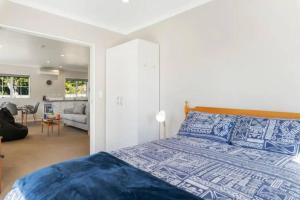 a bedroom with a bed and a living room at Grace Cottage in Turangi