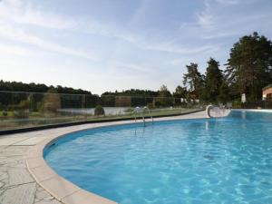 a large swimming pool with blue water at Chalet in Corrèze by Lake Meyrignac in Madranges +13 photos