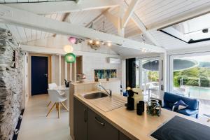 a kitchen with a sink and a large window at Le Cabanon Grand-Heid 2-4p in Lierneux