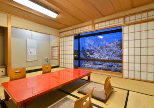 a room with a red table and chairs and a window at Hanayashiki Ukifune-en in Uji +122 photos