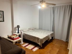 ein weißes Schlafzimmer mit einem Bett und einer Couch in der Unterkunft Nice apartment on Las Americas Beach in Playa de las Americas + 30 Fotos