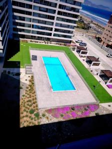 Hermoso depto con vista al mar y solo 50 mtrs de la playa في لا سيرينا: منظر علوي لحوض سباحة في مبنى