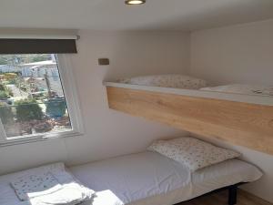 two bunk beds in a small room with a window at Charming Breebos Getaway in Rijkevorsel +13 photos