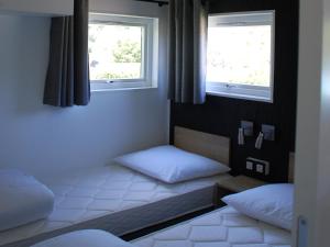 deux lits dans une chambre avec deux fenêtres dans l'établissement Chalet in Baalse Hei with Modern Comforts, à Turnhout
