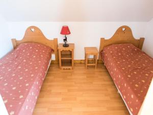 two beds in a room with a table and a lamp at Balcony Views in Northern Alps in Giez