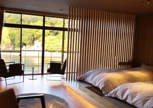 a bedroom with a bed and a large window at Hanayashiki Ukifune-en in Uji