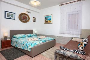 ein Schlafzimmer mit einem Bett und einer Couch in der Unterkunft Apartments by the sea Grebastica, Sibenik - 461 in Grebaštica