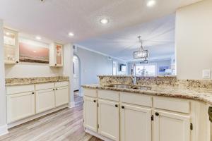 Una cocina con gabinetes blancos y un fregadero. en Island South 7, en St. Augustine