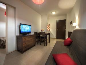 a living room with a television and a dining table at Apartment in Les Eyzies near Font-de-Gaume in Les Eyzies-de-Tayac