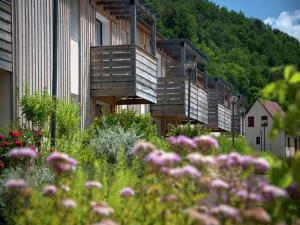 a row of wooden buildings with flowers in the foreground at Apartment in Les Eyzies near Font-de-Gaume in Les Eyzies-de-Tayac