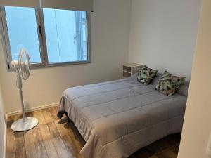 a bedroom with a bed with a fan and a window at Departamento nuevo en el centro in Mar del Plata
