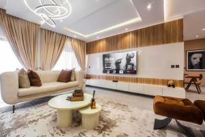 a living room with a couch and a tv at George Residence Banana Island Road, Ikoyi in Lagos