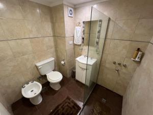 a bathroom with a toilet and a glass shower at Departamento nuevo en el centro in Mar del Plata