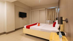 a bedroom with a bed and a tv on the wall at RedDoorz at Samat Mandaluyong in Manila