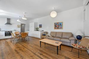 una sala de estar con un sofá y una mesa en Greenwood Cottage - Close to CBD, Leafy Backyard, en Bathurst