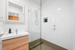 Un baño blanco con lavabo y ducha. en Greenwood Cottage - Close to CBD, Leafy Backyard, en Bathurst 18 fotos más