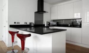 a kitchen with a black counter and red stools at Clamshell Land - Royal Mile in Edinburgh