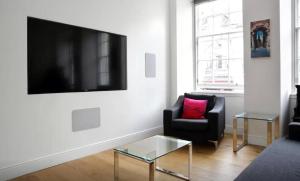 a living room with a black chair and a tv at Clamshell Land - Royal Mile in Edinburgh