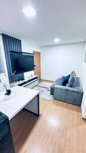 salon z kanapą i telewizorem z płaskim ekranem w obiekcie Apartamento novo e completo próximo Arena Pantanal w mieście Cuiabá