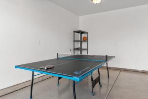 a ping pong table with a tennis racket on it at House It Going home in Washington +32 photos