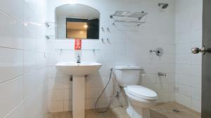 a white bathroom with a toilet and a sink at RedDoorz at Samat Mandaluyong in Manila +23 photos
