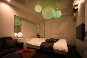 a bedroom with a bed and a couch and lights at プリンセスプリンセス秋田大町 in Akita