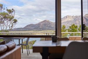 a living room with a view of the mountains through a window at The Arthouse Freycinet in Coles Bay