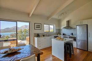 a kitchen with a table and a kitchen with a view at The Arthouse Freycinet in Coles Bay