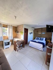 a bedroom with a bed and a desk and a television at Villa Rosa e Mar - Praia do Rosa in Imbituba +64 photos