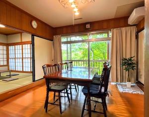 a dining room with a table and chairs and a large window at Solarium komoro in Komoro +21 photos