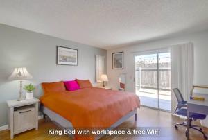 a bedroom with a king bed with a desk and a window at Entire Private 3-BR House, Ranch Style w Gated Yard near Beach, Available Now in Imperial Beach