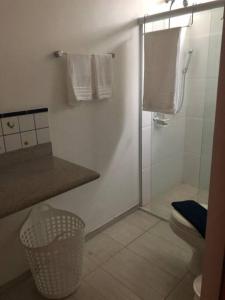 a bathroom with a shower and a toilet and towels at Apartamento maravilhoso na Pitangueiras Guarujá in Guarujá