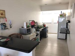 a kitchen with a refrigerator and a counter top at Apartamento maravilhoso na Pitangueiras Guarujá in Guarujá +6 photos