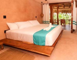 Schlafzimmer mit einem großen Bett und einem Balkon in der Unterkunft Hotel Rinconcito de Mazunte in Santa María Tonameca