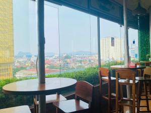 a restaurant with tables and chairs and a large window at Khách Sạn Hoàng Mấm Minh Cầu - Best City view in Thái Nguyên