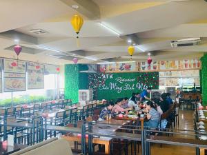 a dining room with people sitting at tables in a restaurant at Khách Sạn Hoàng Mấm Minh Cầu - Best City view in Thái Nguyên