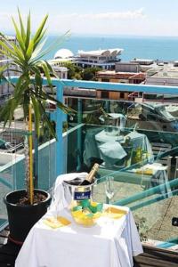 stół z butelką wina i roślina na balkonie w obiekcie Hotel San Carlo w Lignano Sabbiadoro